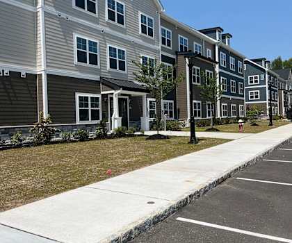 Apartment building with a parking lot in front.