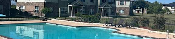 a swimming pool with an apartment building in the background