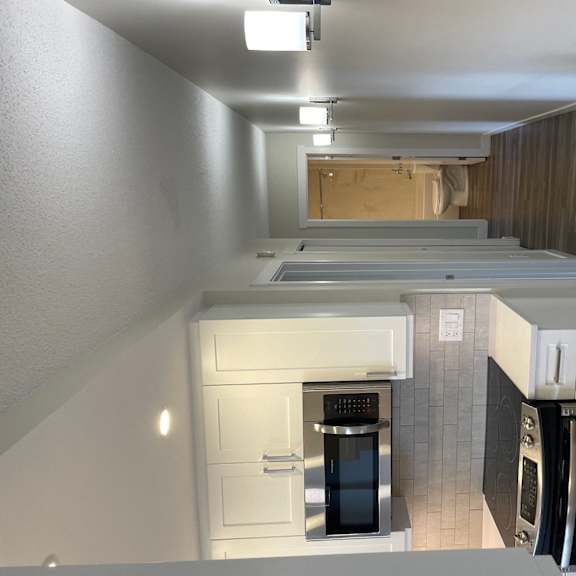 an overhead view of a kitchen with white cabinets and appliances