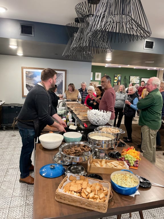 a group of people standing around a buffet table with food at Vue at Bluestone, Duluth, Minnesota