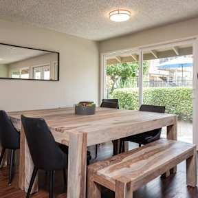 a dining room with a wooden table and chairs