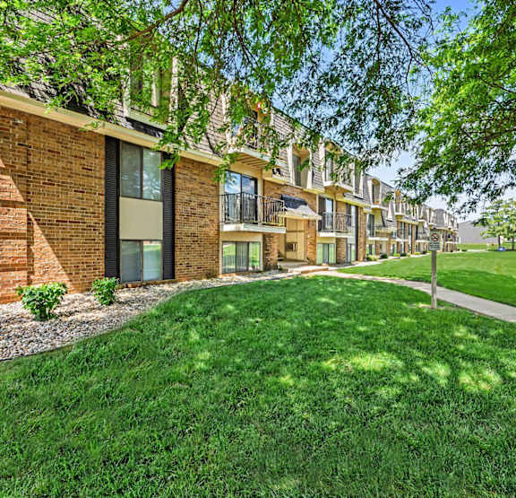 an apartment building with a green lawn at Brookside Apartments, Springfield, MI, 49037