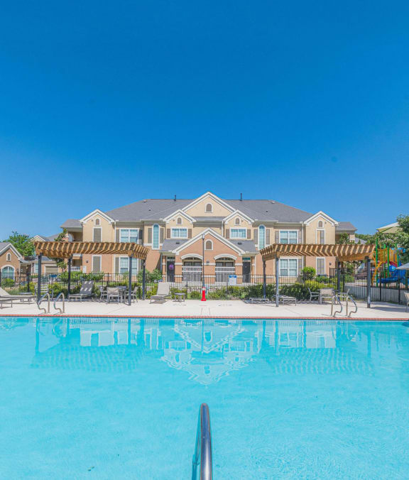 our apartments offer a swimming pool with a building in the background at Woodway Village, Austin, TX 78744