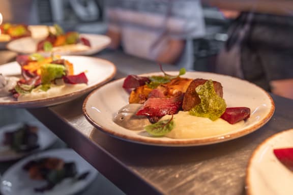 A woman in a yellow sweater is reading a book on a bus.