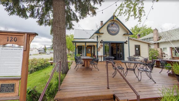 the deck outside of a restaurant with tables and chairs