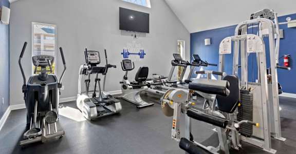 A gym with a variety of exercise equipment including treadmills, stationary bikes, and weight machines.at Coastline Apartments, Florida, 32547