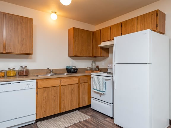 a kitchen with a white refrigerator freezer next to a white dishwasher