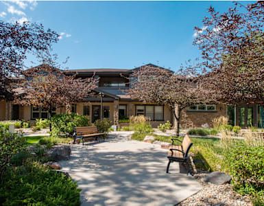 a courtyard with benches and a building in the background