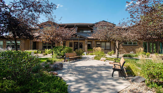 a courtyard with benches and a building in the background