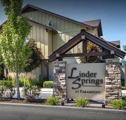A sign for Linder Springs at Paramount stands in front of a building.