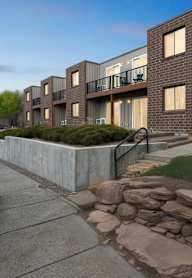 A modern brick building with a stone wall in front.