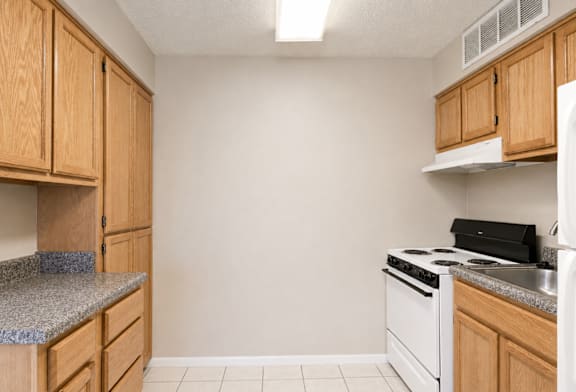 A kitchen with wooden cabinets and white appliances.
