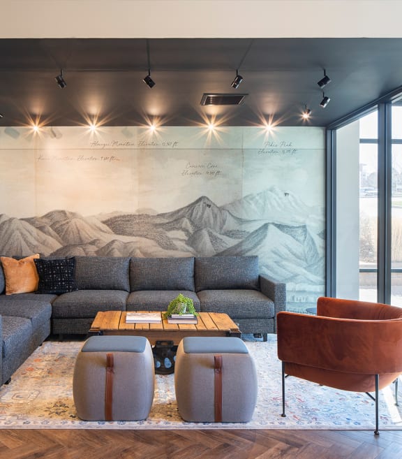 a living room with a mural of a mountain range on the wall