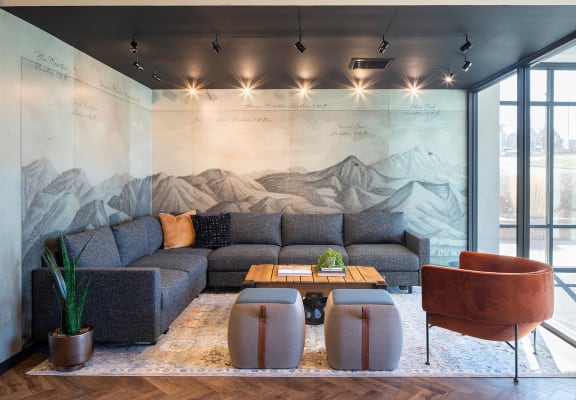 a living room with a mural of a mountain range on the wall