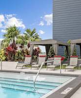 Rectangular pool with lounge chairs by apartments at Bay Village 1 Apartment in Palmetto Bay, FL