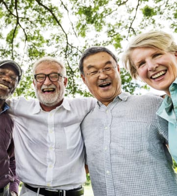 Five elderly people linking arms and smiling