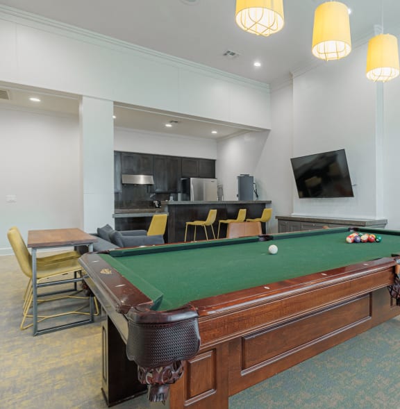 a community room with a pool table and a tv