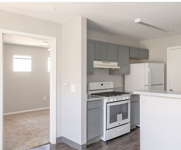 an empty kitchen with white appliances and a white counter top