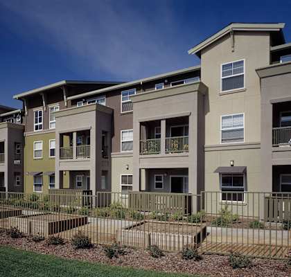 an exterior view of an apartment complex with a fence