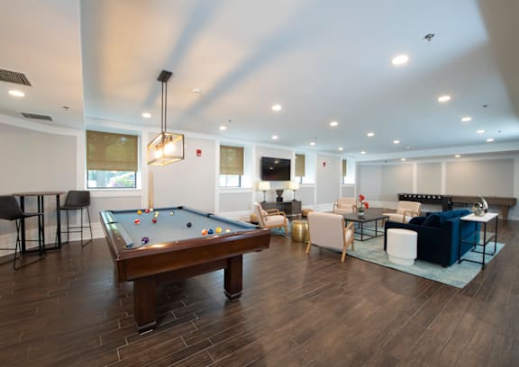 A billiard table is in the middle of a room with a pool table.