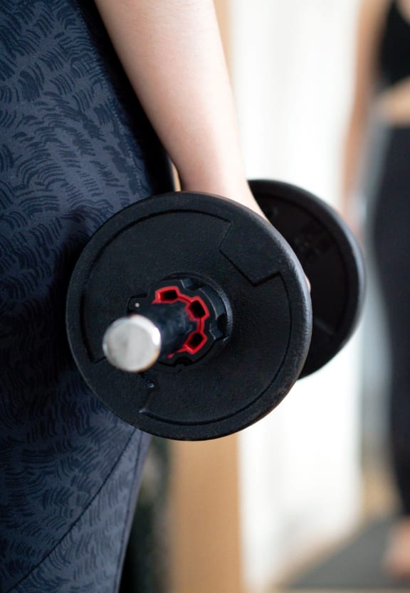 a woman holding a dumbbell in front of a mirror at Sedona Springs, Texas, 78749