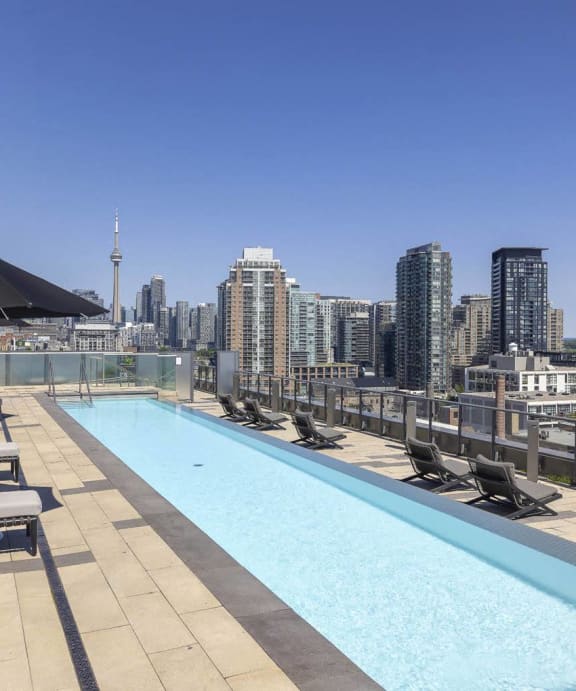 the pool on the rooftop of a building with a view of the city