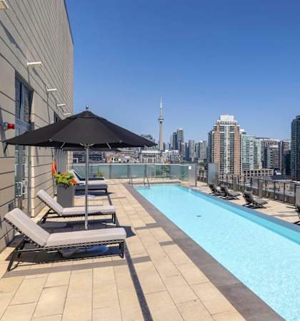 the pool on the rooftop of a building with a view of the city