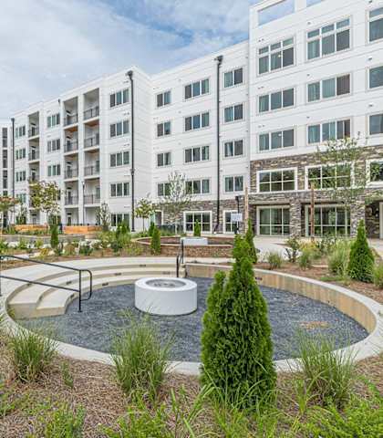 an outdoor courtyard with a fountain and a building in the background