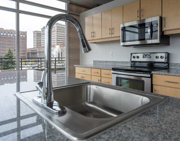 A modern kitchen with a stainless steel sink and a stove top oven.