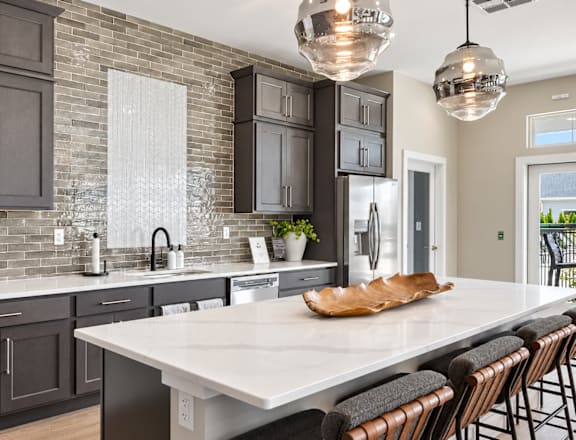 A kitchen with a white countertop and dark cabinets.