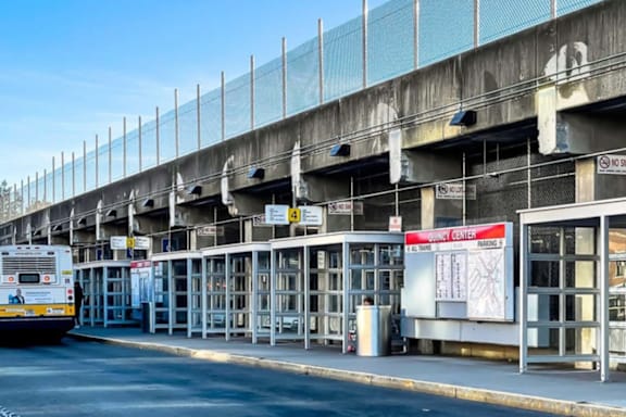 Two buses are parked at a bus station.