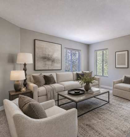 A living room with a couch, chairs, and a coffee table.