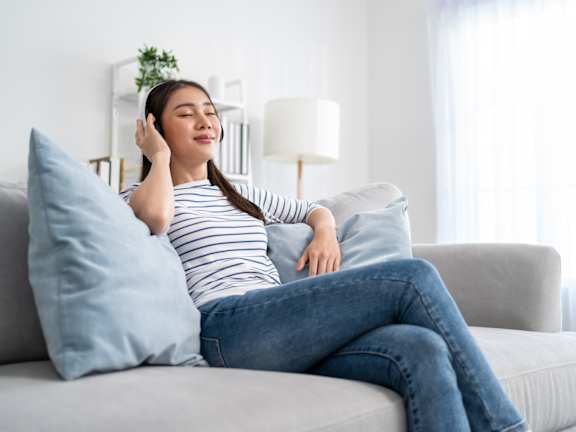A woman is sitting on a couch at The Maverick Apartments, Kitchener, Ontario