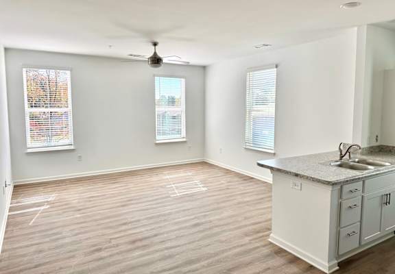 an empty kitchen and living room with a sink and a counter
