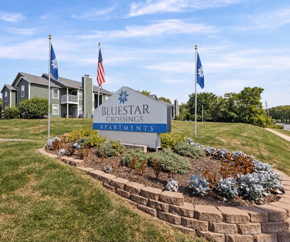 The sign in front of the building says Bluestar Crossings Apartments.