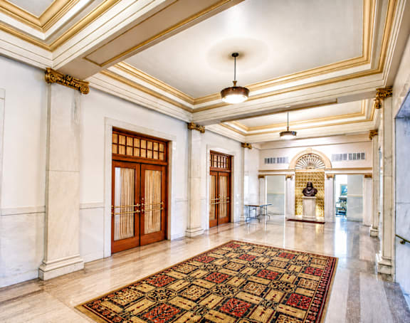 A large, ornate hallway with a patterned carpet and a chandelier.