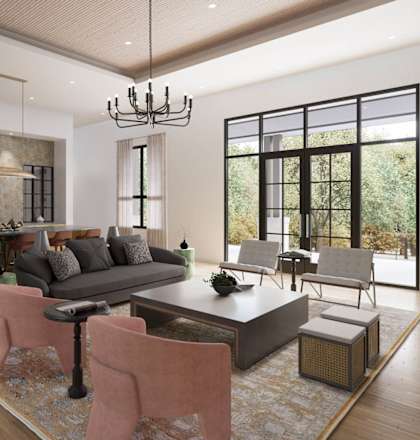 A modern living room with a grey sofa, pink chairs, and a wooden floor.