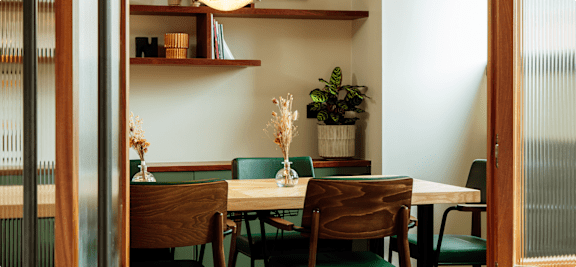 A dining room with a table and chairs.