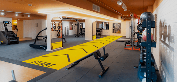 A gym with a yellow start line on the floor.