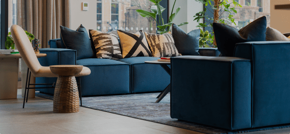 a living room with blue couches and pillows and a rug
