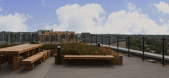 a roof deck with benches and a view of the city