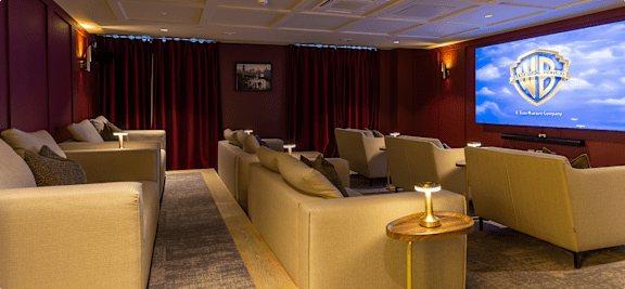 A room with a large screen and comfortable seating.