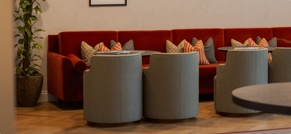 a living room with tables and chairs and a red couch