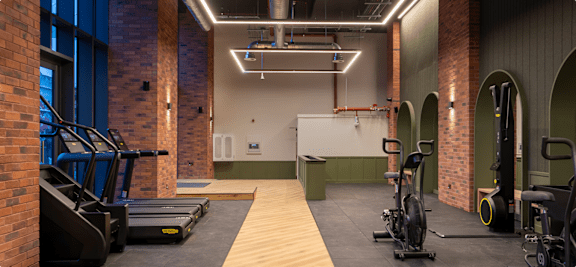 A gym with treadmills, exercise bikes and weights.
