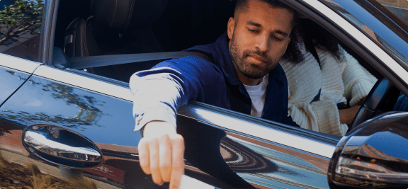 a man sticking his hand out of a car window