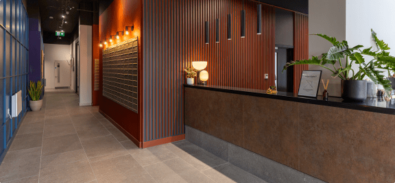 a view of a lobby with a reception desk and a plant
