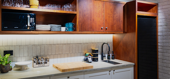 A kitchen with a white counter top and wooden cabinets.