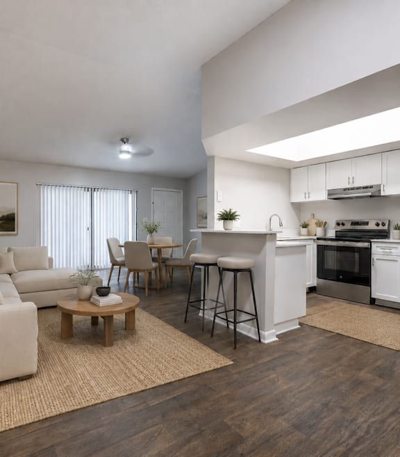 A modern living room with a white couch, a wooden coffee table, and a kitchen area in the background.