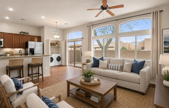 A well-lit living room with a ceiling fan and a large window.