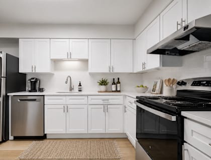 A modern kitchen with white cabinets and stainless steel appliances.